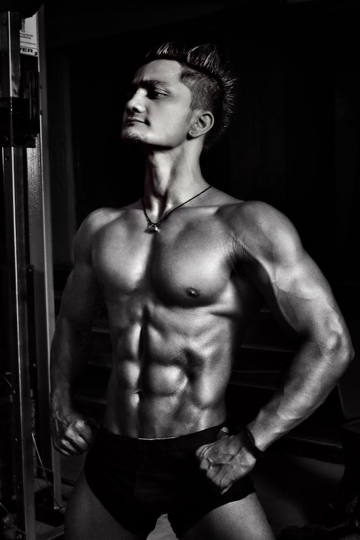 Dynamic black and white image of a muscular male bodybuilder striking a powerful pose.
